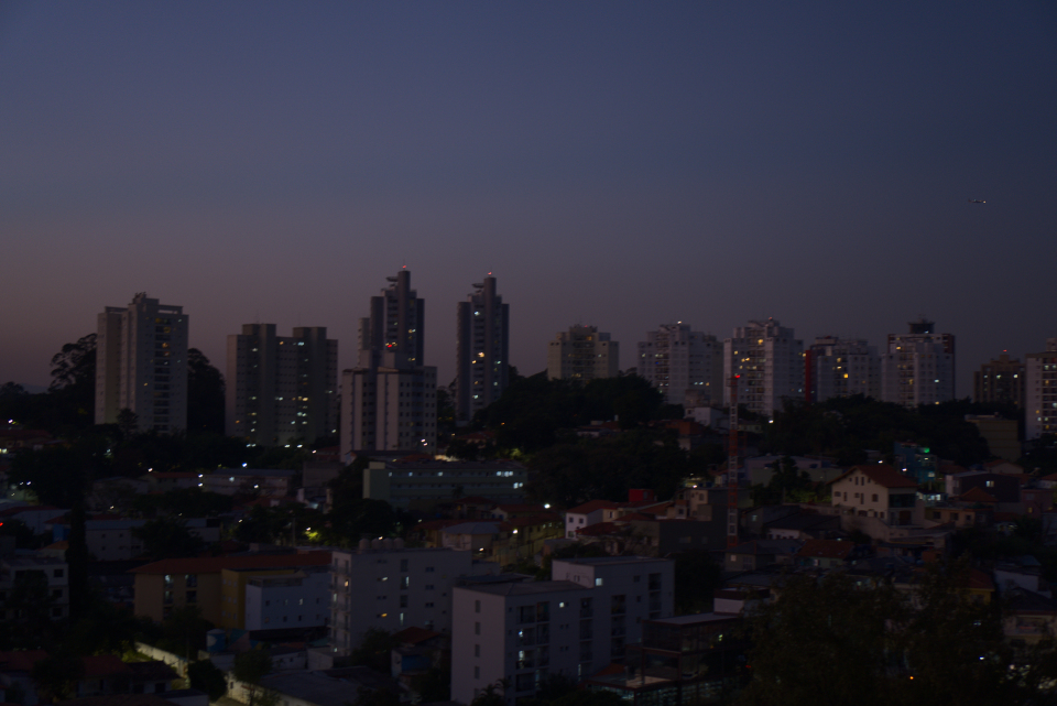 Cidade ao cair da noite com luzes nas janelas